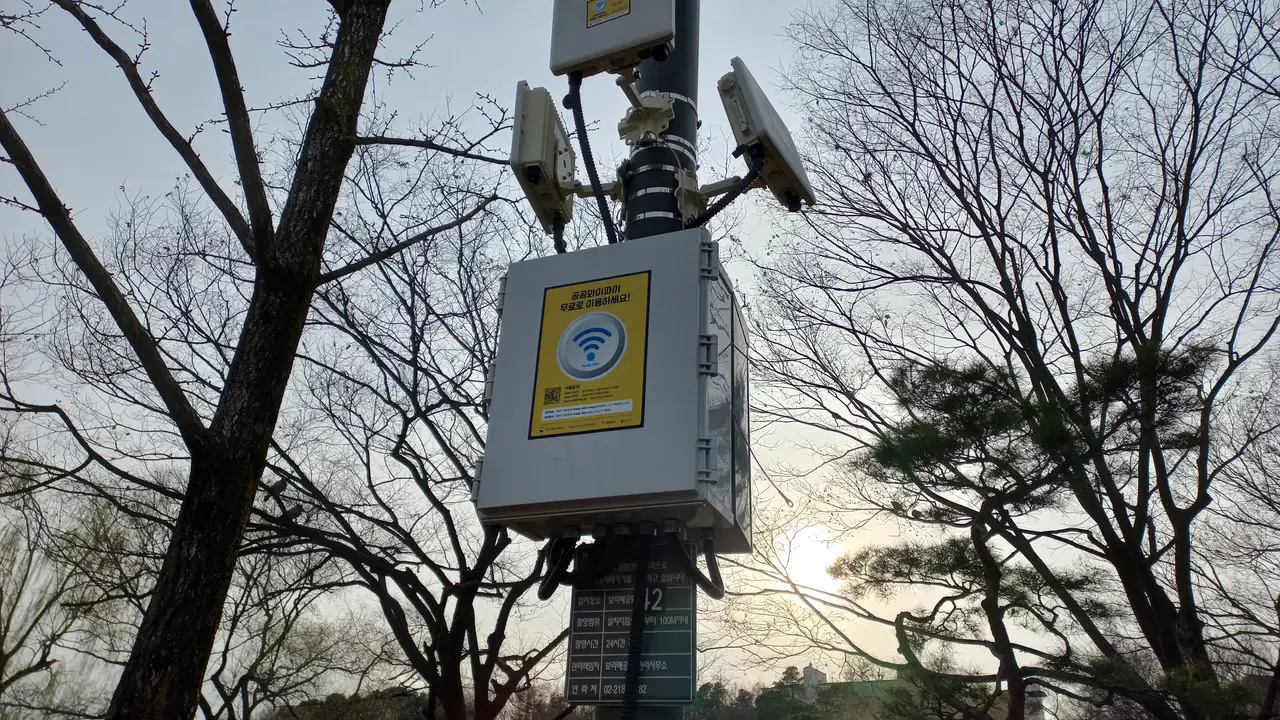 A public Wi-Fi unit mounted on a lamp post in Boramae Park, Seoul, with a free-use sign