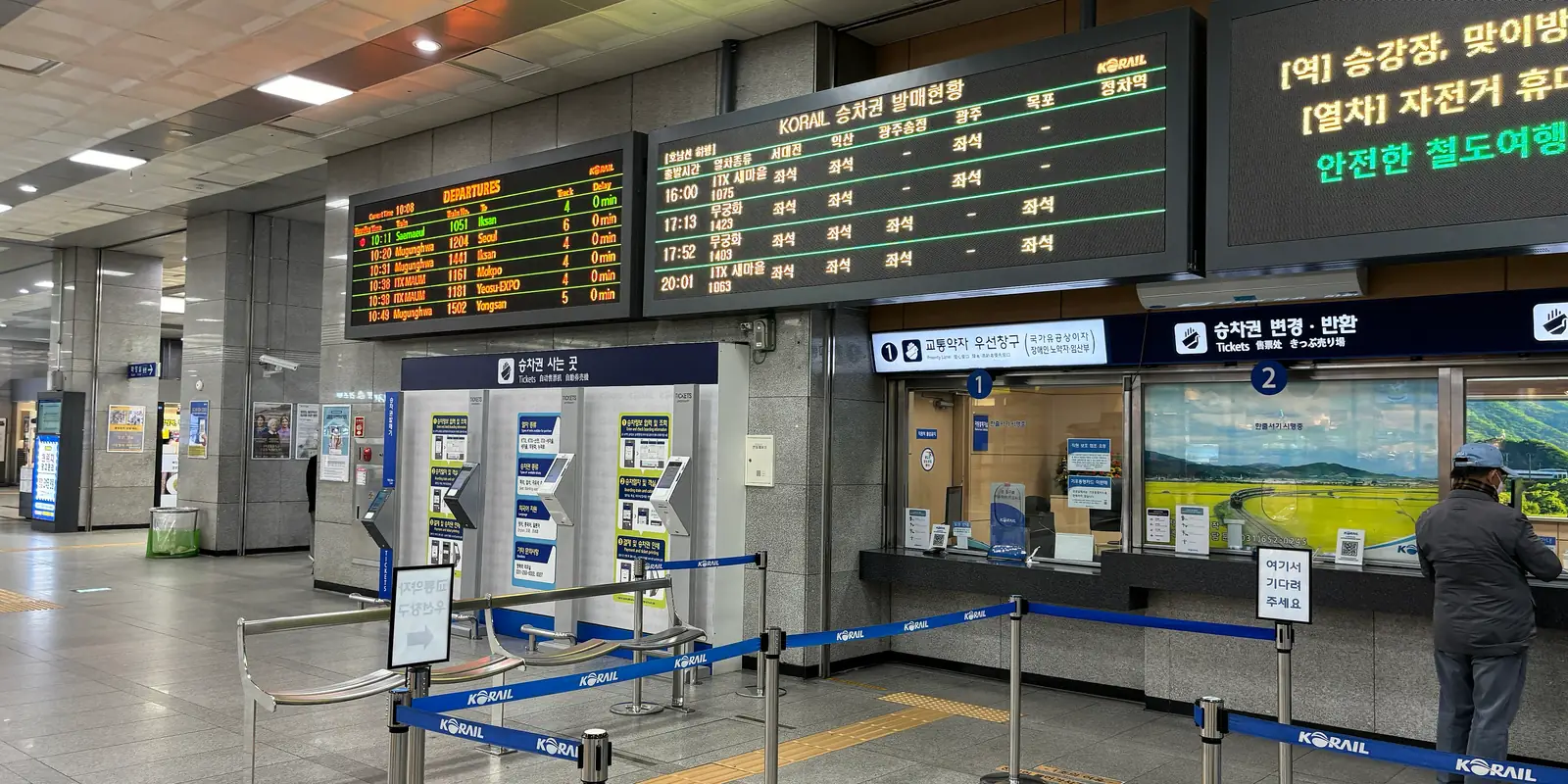 Korail's long-distance ticket area at Pyeongtaek Station: ticket machines under a blue 'Tickets' sign, staffed ticket windows on the right, and a departure board and a KORAIL seat-availability board overhead